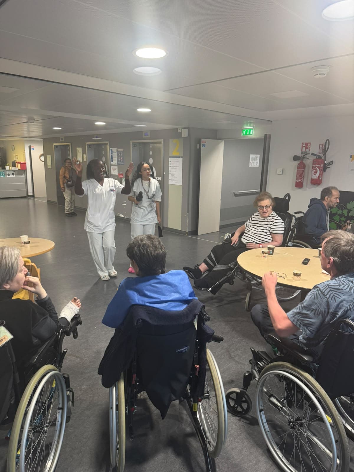Une bénévole échange avec des patients assis en cercle pendant une activité.