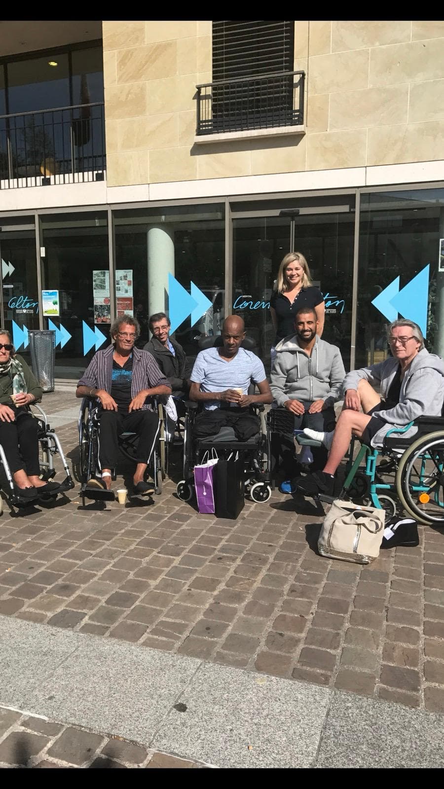 Groupe de patients et de bénévoles devant l'hôpital, lors d'une sortie.