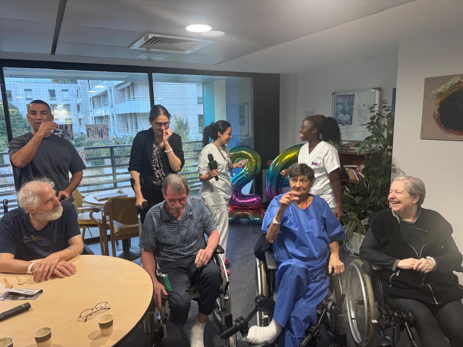 Patients et bénévoles réunis, sourires et ballon.