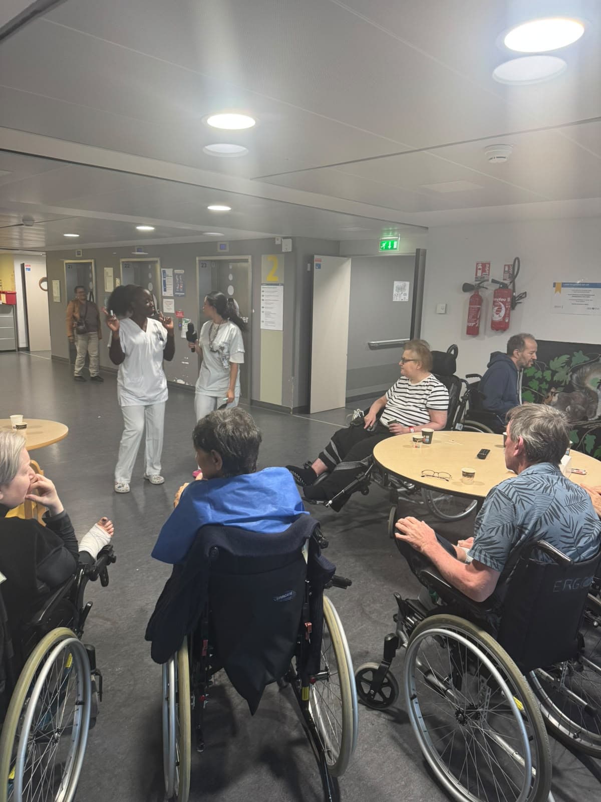 Les bénévoles dansent dans le couloir du service, les patients regardent.