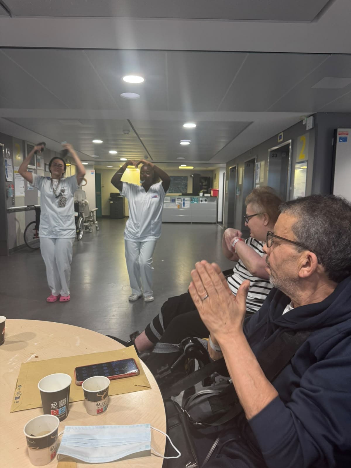 Une bénévole lève les bras pendant l'animation, un patient applaudit.